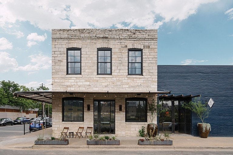 Historic stone building exterior with native street planters